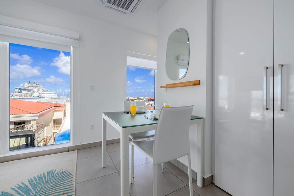 A modern fitness center spans floor-to-ceiling windows overlooking the sparkling sea, where treadmills, bikes, and weights await your waterfront workout.