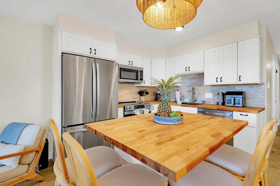 Puako Beach Condo #102 – Fully equipped kitchen with stainless steel appliances and island.