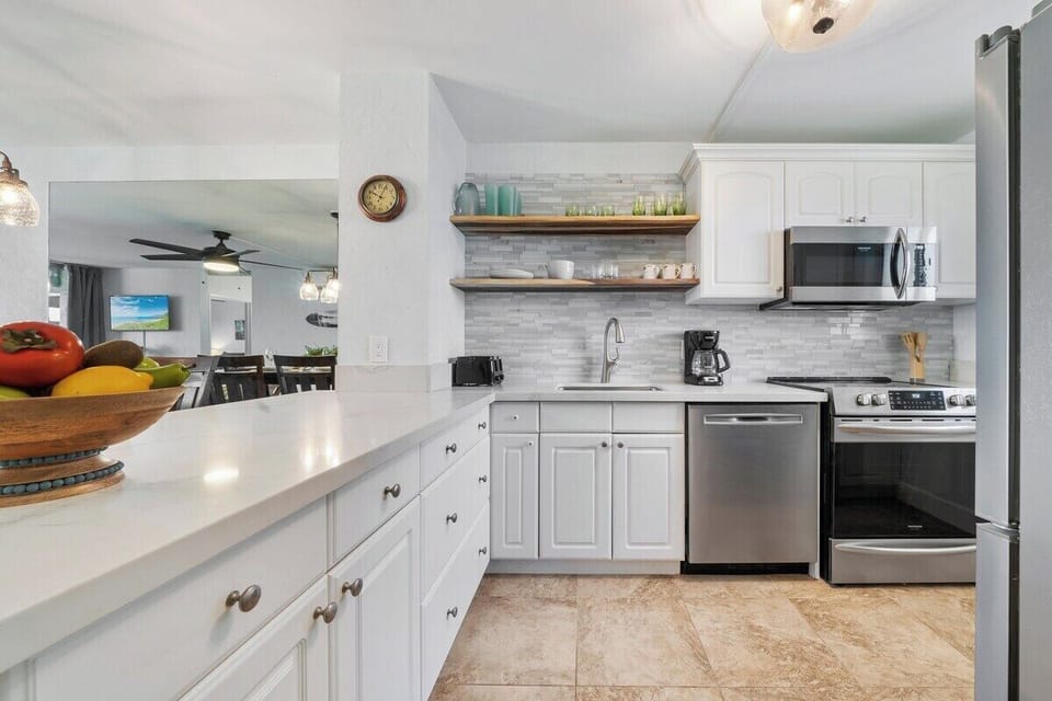 A crisp, well‑appointed kitchen offers white cabinetry, stainless appliances, and a clean, airy feel.