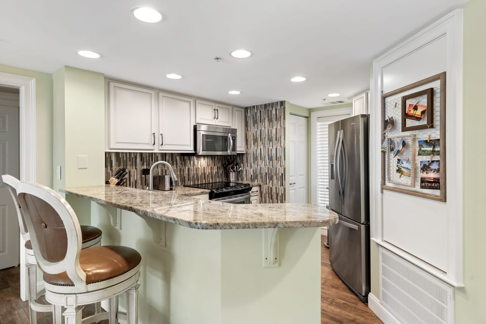 Fully stocked kitchen with granite and stainless steel.
