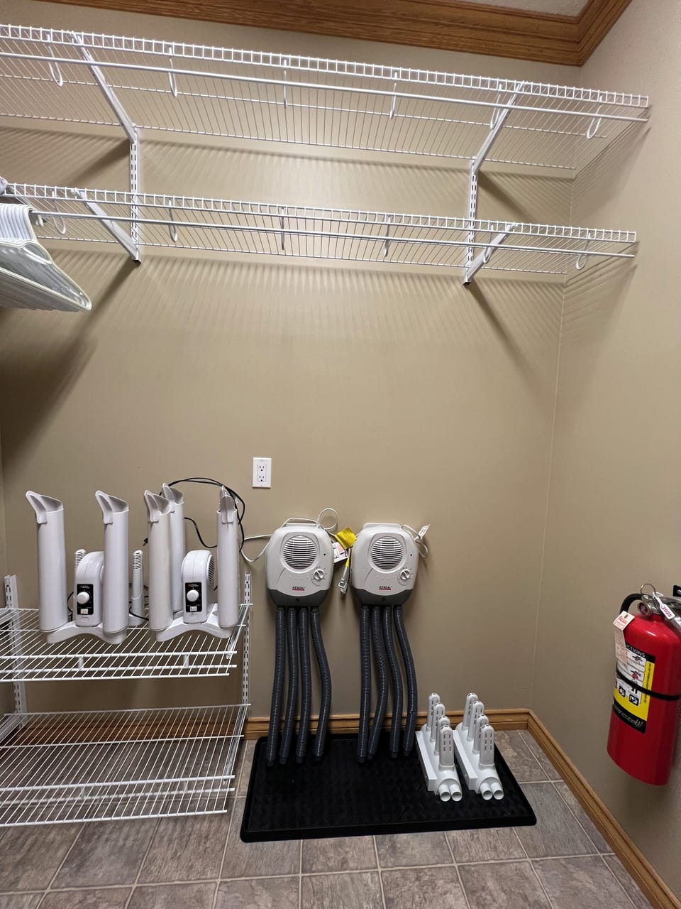 Boot and equipment dryers in the laundry room with stand up fan.