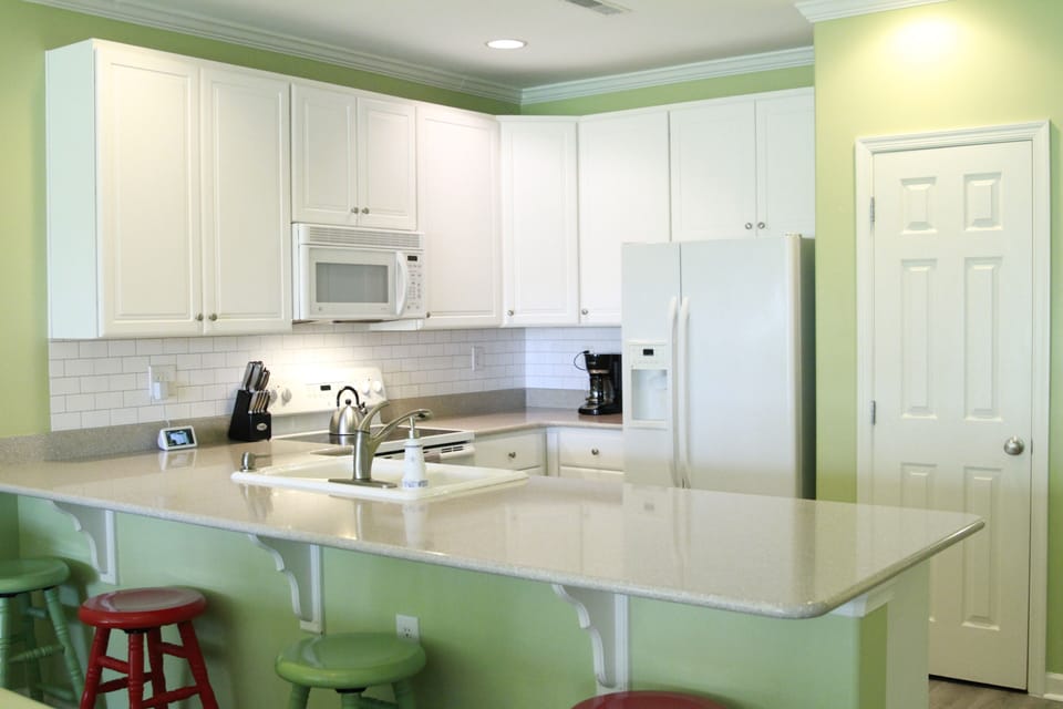 open kitchen over looking living area with additional bar seating
