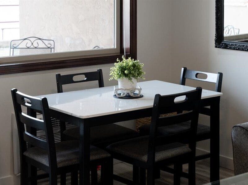 Enjoy intimate meals at your elegant dining table, perfectly positioned by the window with fresh flowers brightening each gathering.