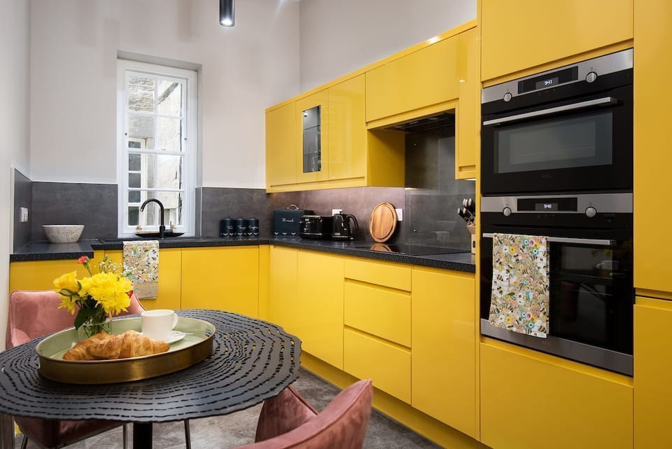 The Scott Apartment - the kitchen in bright Bumble Bee yellow adds a heavenly pop of colour