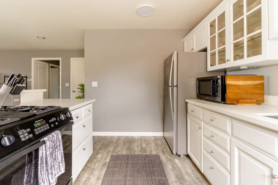 Kitchen. Stove, microwave, cutting board, fridge, freezer.

