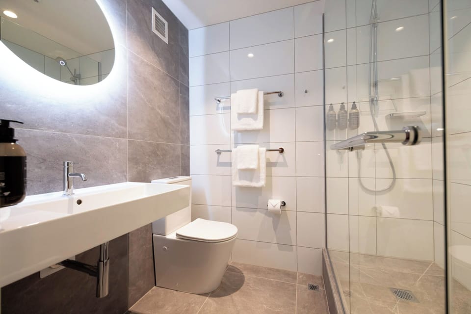 One Bedroom King Suite with Lounge | Bathroom | Shower, eco-friendly toiletries, hair dryer, towels