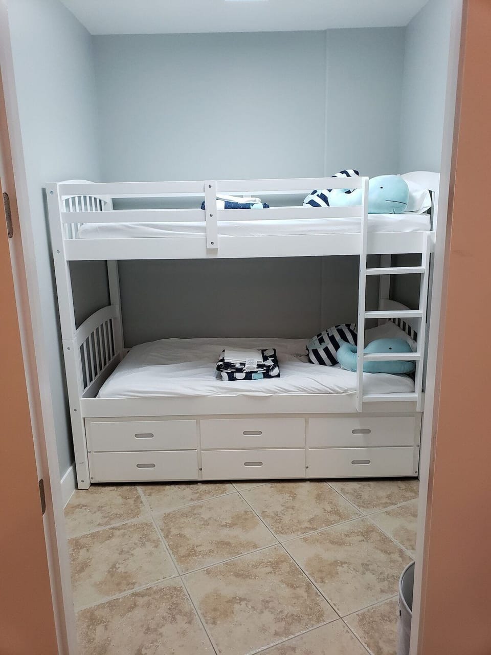 Bunk beds with trundle tucked away in closet space in the bedroom