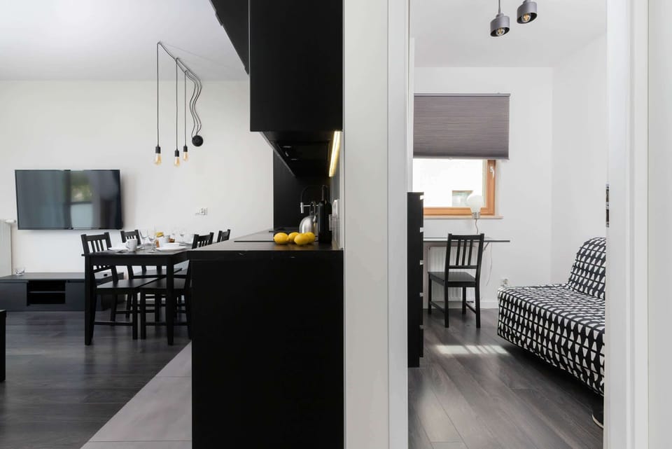 An open concept area combining a dining table with black chairs and the living room, creating a cohesive space.
