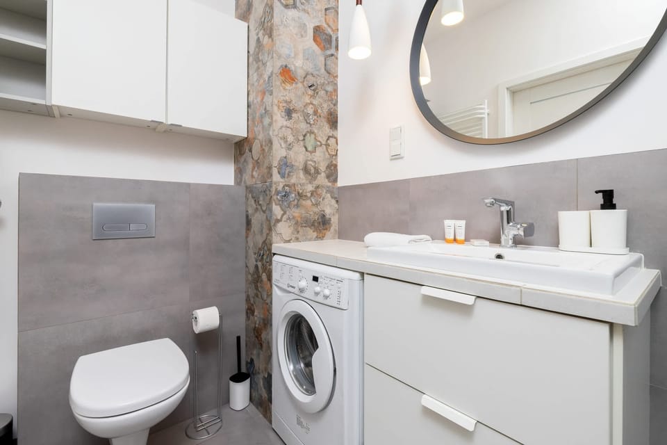 A well-organized bathroom with a vanity mirror, sink, and toiletries, designed with a modern aesthetic.