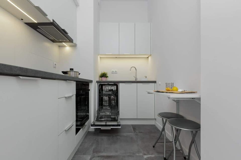 A sleek, modern kitchen with clean, white cabinets, stainless steel appliances, and a stylish minimalist design, creating a bright and efficient cooking space.
