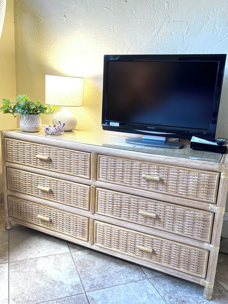 6 drawer dresser in master bedroom with cable TV, AC unit and blackout curtains.