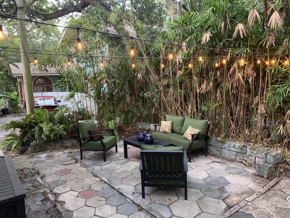 Spacious and private patio with outdoor lighting and furniture.