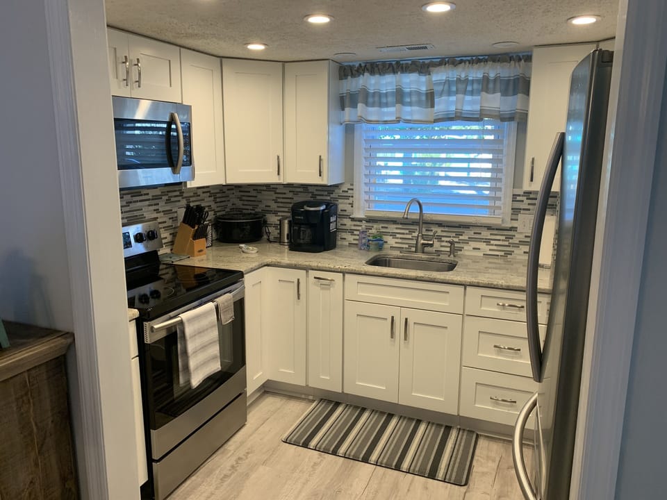 Kitchen has a full size range, microwave, toasteroven, blender, and refrigerator