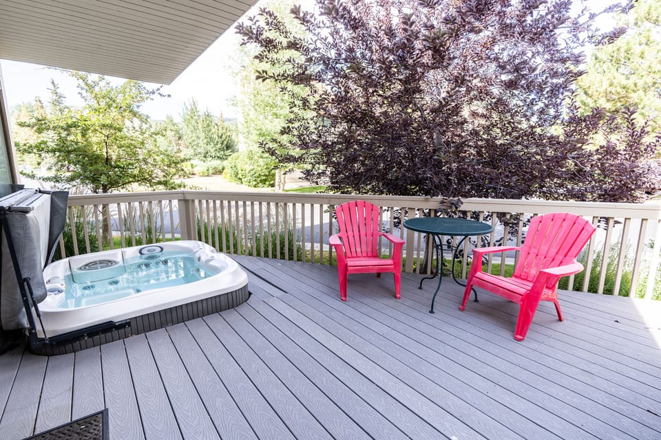 Private hot tub on the deck with open lawn views behind the condo