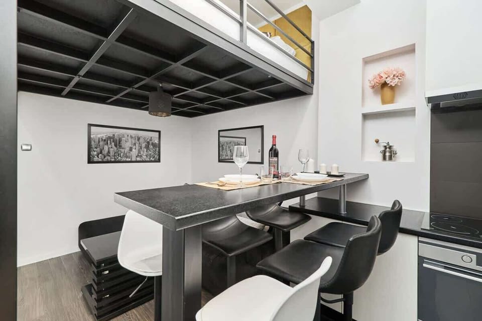 Another angle of the living room showing a black dining table with chairs and modern decor.