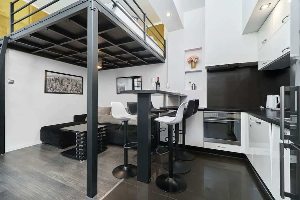 A compact kitchen featuring modern appliances and a dining table, optimized for convenience.