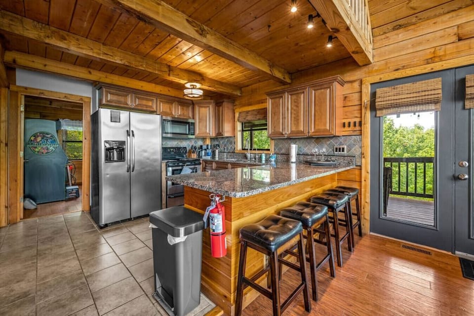 Stainless steel appliances throughout, including a smart human trash bin, refrigerator with ice and water dispenser, electric stove and oven, dishwasher, Keurig coffee machine, toaster, blender, tea kettle, and more.