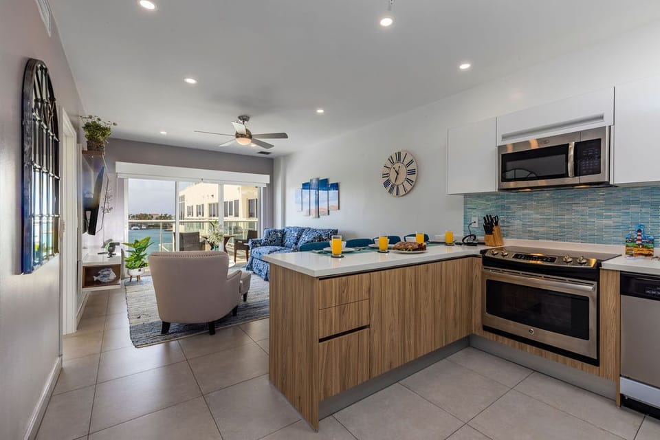 Step into your open-concept retreat where coastal views await—your fully equipped kitchen blends style with function, ready for mornings at the island or gathering with loved ones.