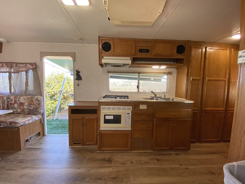 Showing the microwave stove and sink with a view of the outside