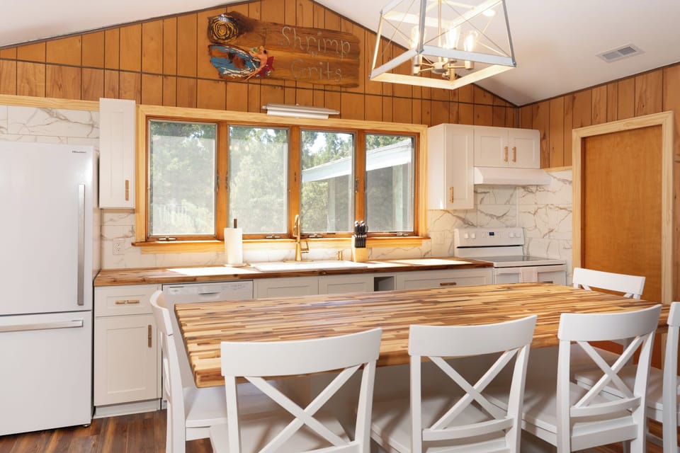 Your fully equipped kitchen blends rustic charm with modern convenience, featuring beautiful wood accents and large windows that flood the space with natural light.