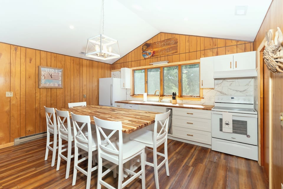Gather around your fully-equipped kitchen island for meals and memories, with warm wood paneling creating a cozy cabin atmosphere.