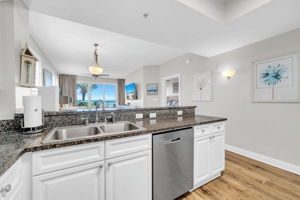 Your fully equipped kitchen features granite countertops, stainless steel appliances, and stunning ocean views through the window.