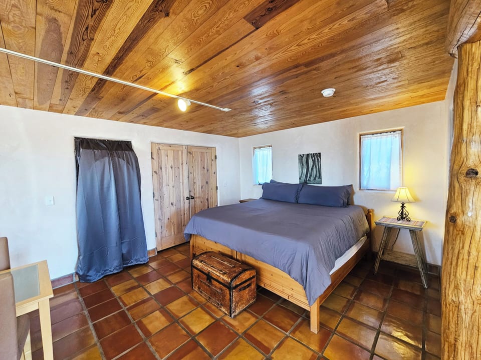 King bed with curtain covering new Washer Dryer