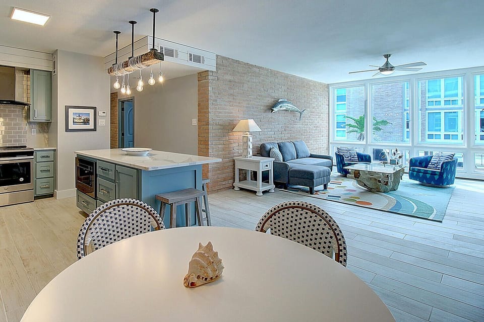 Unwind in your beautifully appointed open-concept space featuring exposed brick, modern kitchen, and comfortable seating overlooking city views.