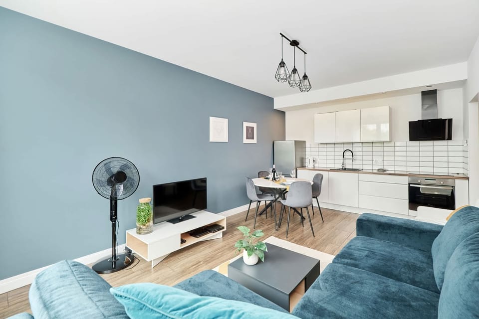 Cozy living room with a corner sofa, TV and dining area.
