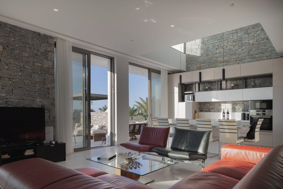 Open-plan living and kitchen area bathed in natural light from floor-to-ceiling windows