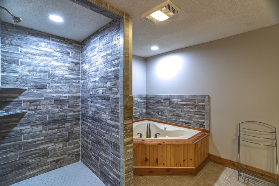 Unwind in the corner soaking tub or rinse off in the spacious walk-in shower, finished with rich stone tile throughout.