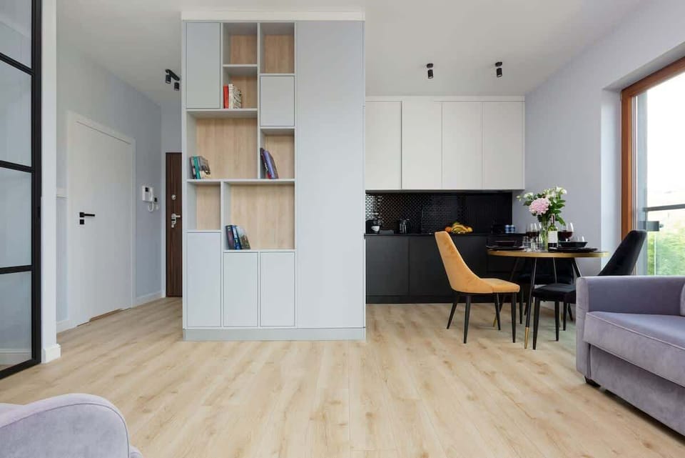 Spacious living room with a double sofa, TV and kitchenette.