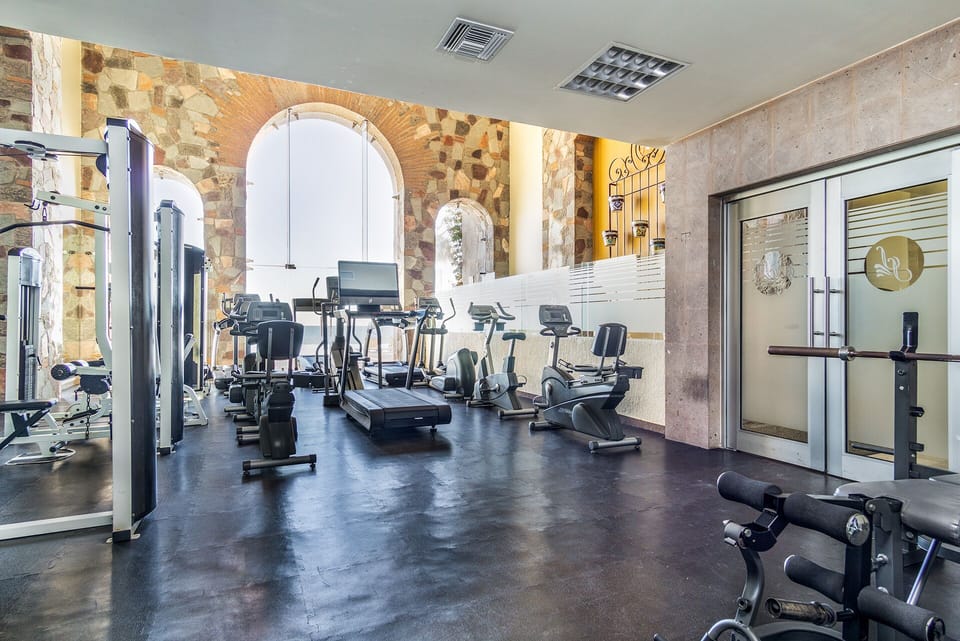 The workout area is up to date, with resistance machines, free weights, and treadmills too.