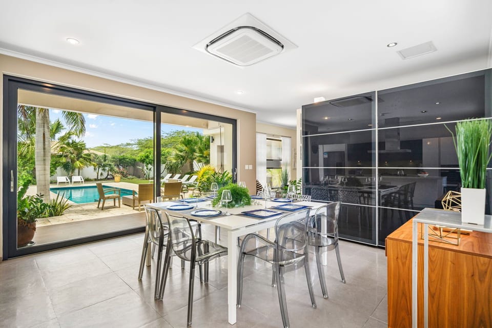Eminent Dining Area of the villa in Noord Aruba Near beach - 8 Persons Dining - Neutral color palette with pops of vibrant hues for a chic contrast - Artfully arranged table settings for a touch of elegance