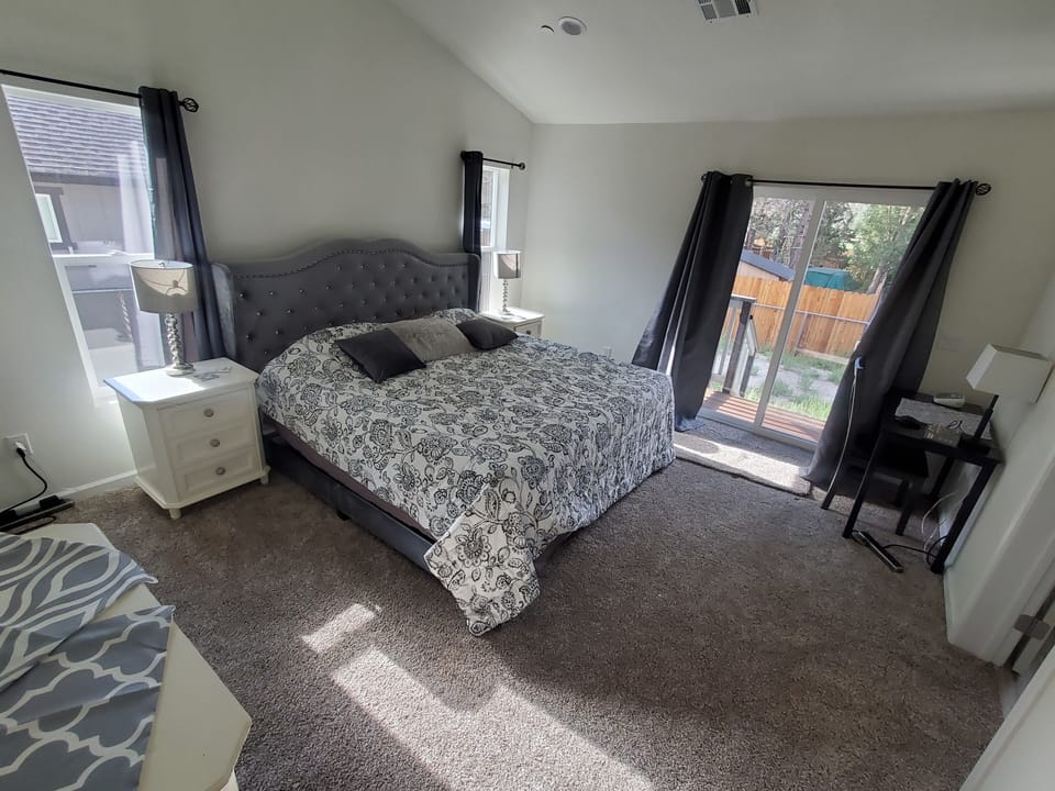 Primary bedroom with king bed, desk, dressers and walk-in closet and ensuite