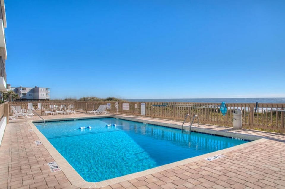 Take a cool dip in the sparkling pool after a fun day at the beach.