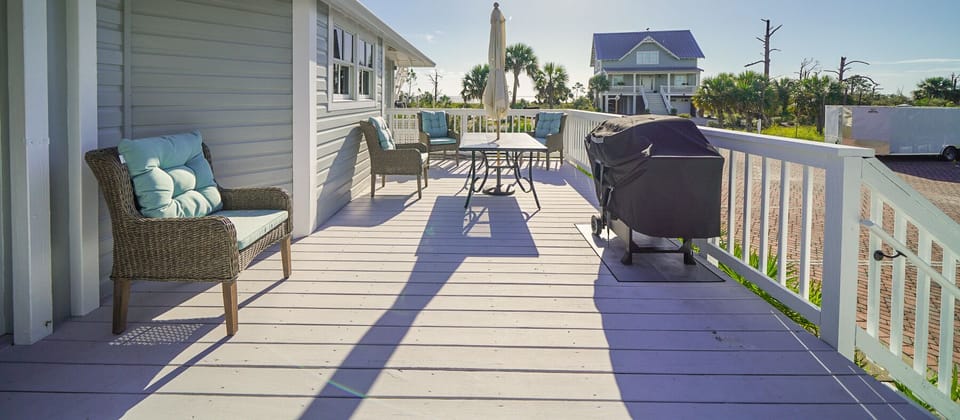 Large deck with partial water views, outdoor dining, and propane grill