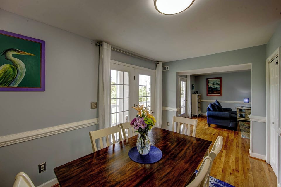 Your bright dining space features a handcrafted table with thoughtful touches, flowing seamlessly into the cozy living room for memorable meals and conversations.
