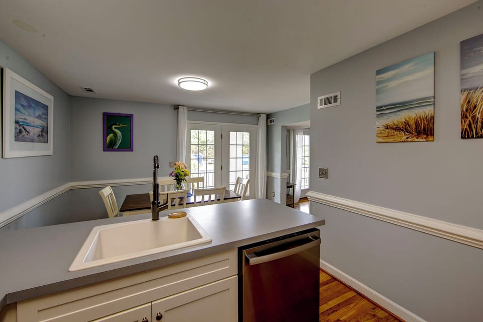 Your bright open kitchen flows seamlessly into the dining area, where natural light streams through French doors creating a warm space for cooking and gathering.