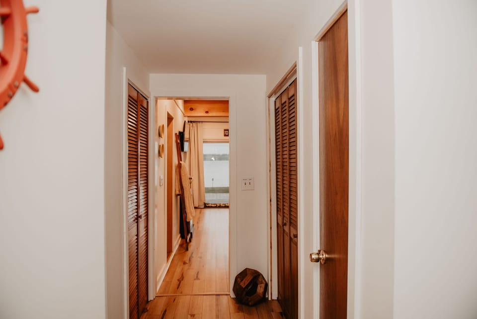 From the moment you walk in, the lake calls. The entry flows into a sunlit living room with floor-to-ceiling views.