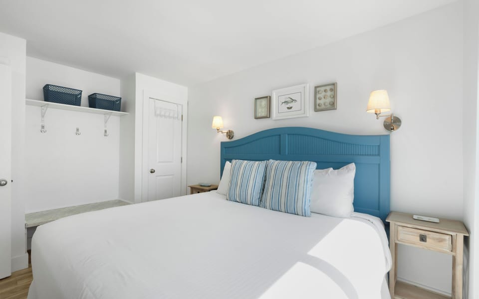 Your cozy bedroom features crisp white linens, coastal blue accents, and warm bedside lighting for peaceful nights.