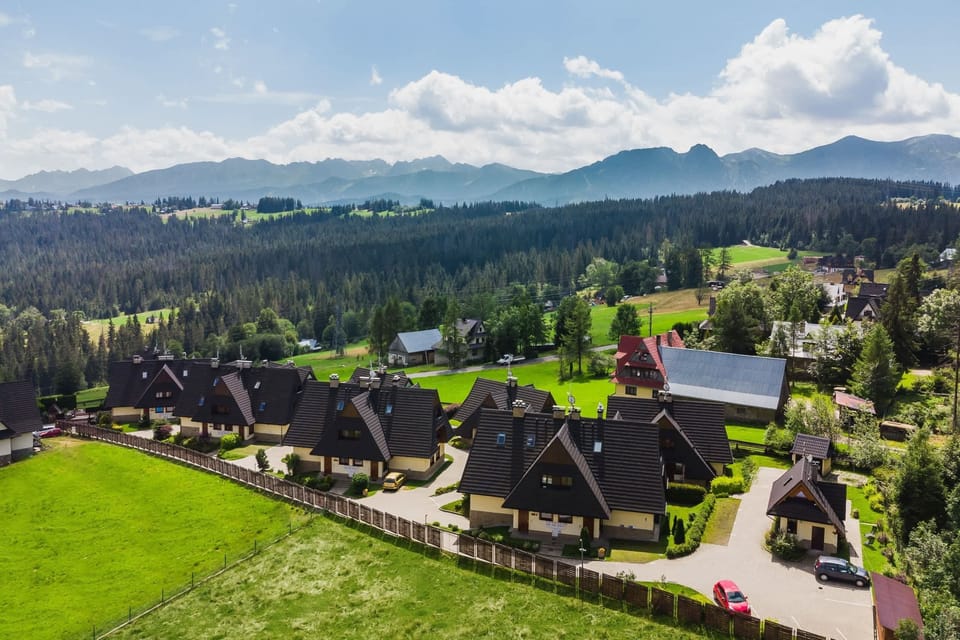  A stunning aerial view of a peaceful mountain village surrounded by lush greenery.
