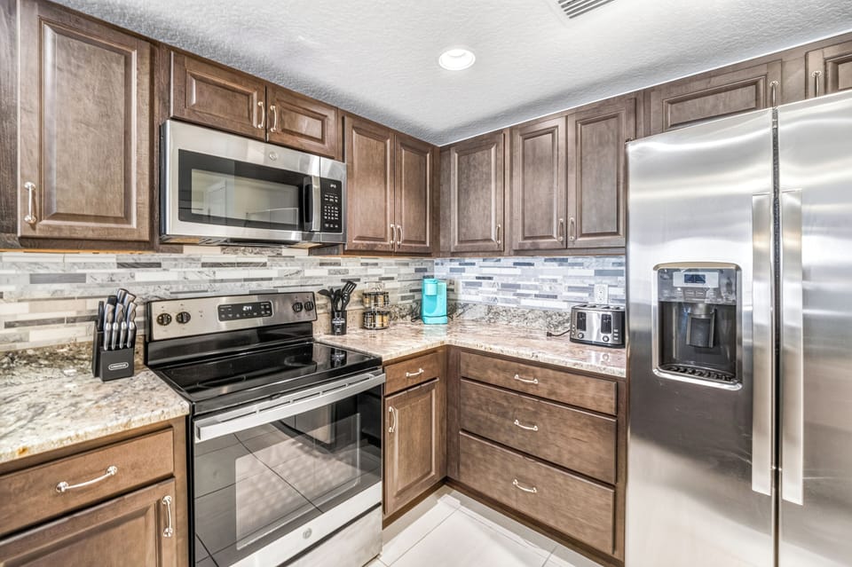 Your fully equipped kitchen features granite countertops, stainless steel appliances, and elegant tile backsplash—ready for you to cook up anything from a quick breakfast to a family feast.