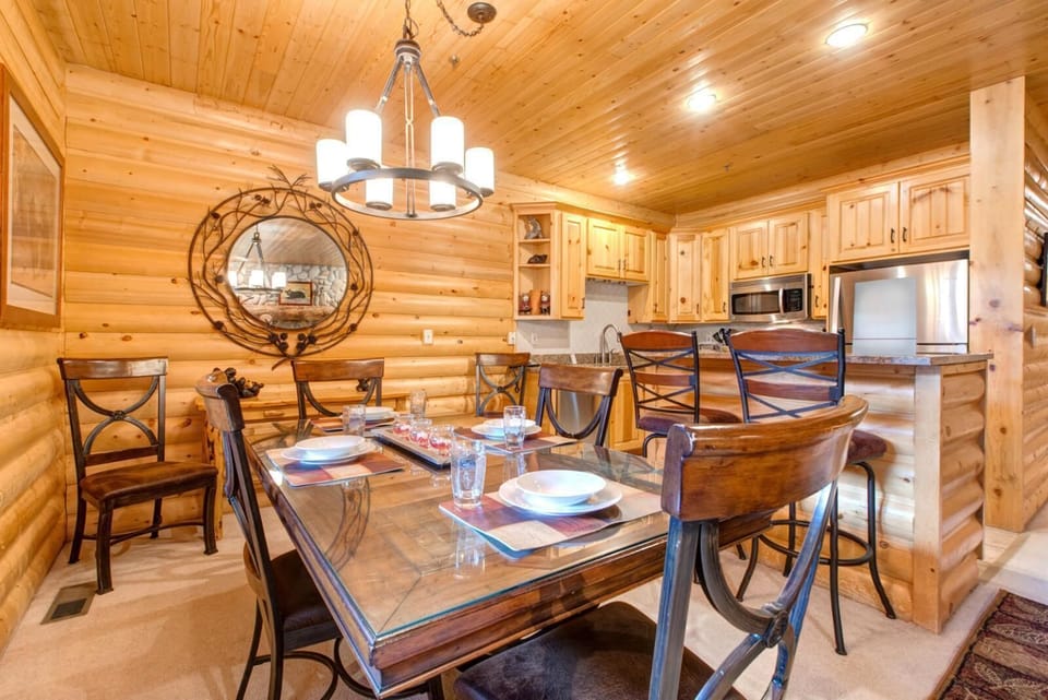 Dining table for six with rustic wood finishes and mountain-inspired lighting for cozy meals in.
