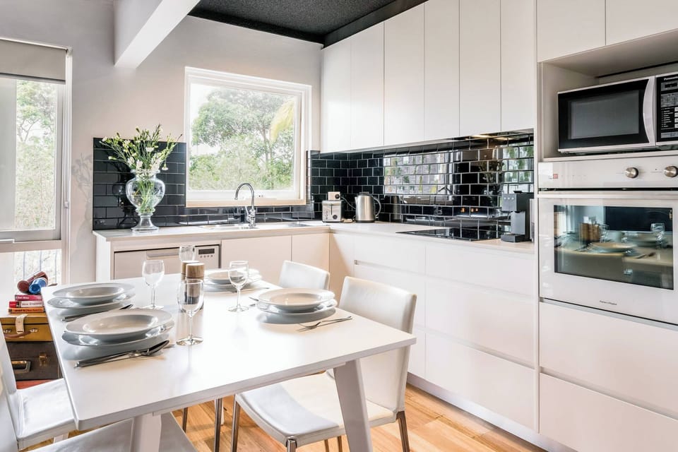 Fully equipped kitchen with a microwave, cooktop, and dining table — ideal for preparing meals and enjoying them in comfort.