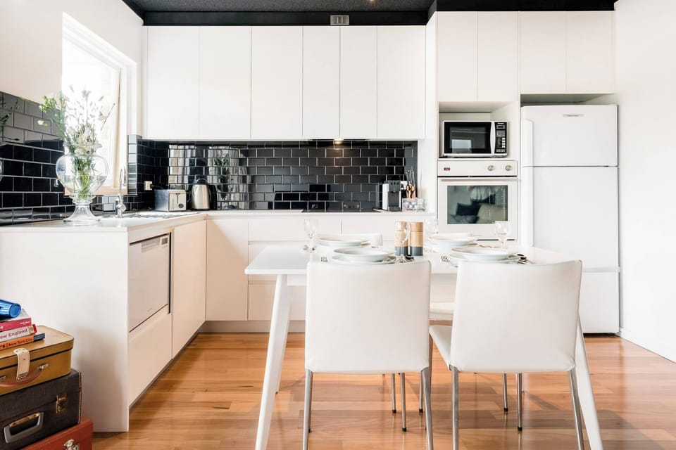 Fully equipped kitchen with a microwave, cooktop, and dining table — ideal for preparing meals and enjoying them in comfort.