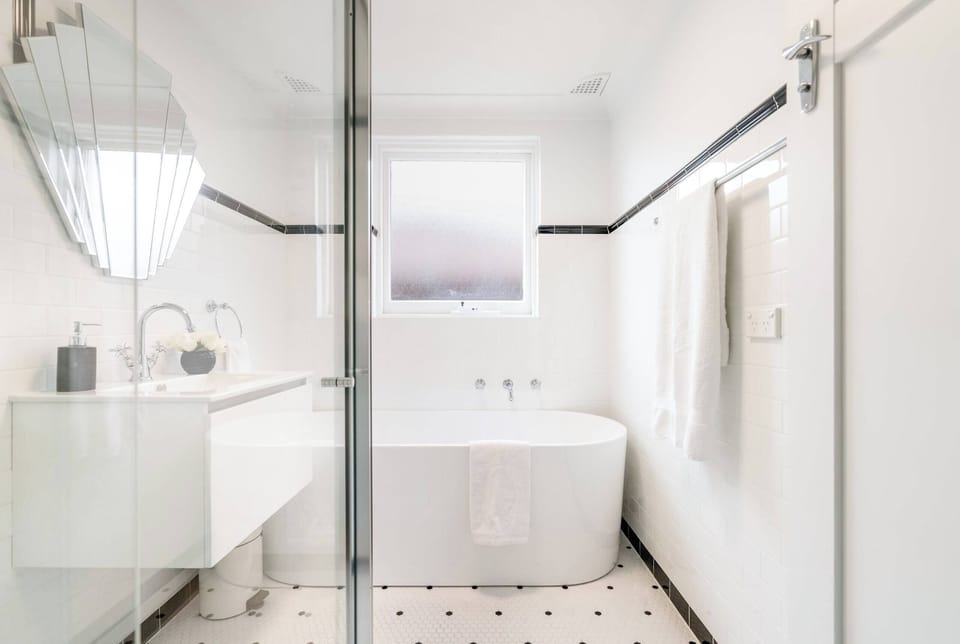 Spacious bathroom featuring a relaxing bathtub and a practical laundry area with a sink — thoughtfully designed for both comfort and convenience, making it perfect for unwinding and taking care of everyday needs.