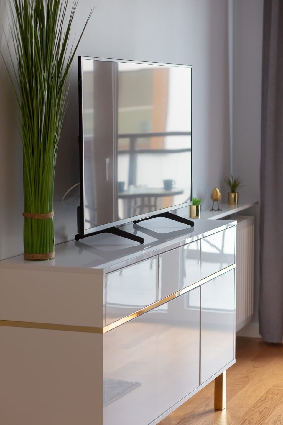 A modern flat-screen TV that sits on a white dresser.