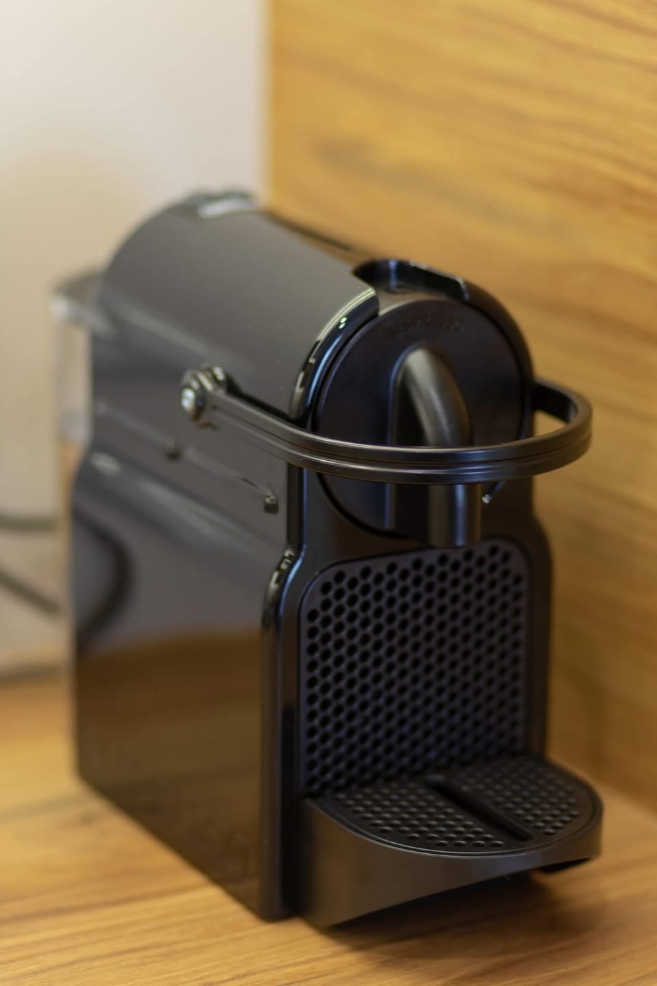 A sleek black Nespresso machine placed on a wooden countertop, perfect for coffee lovers.