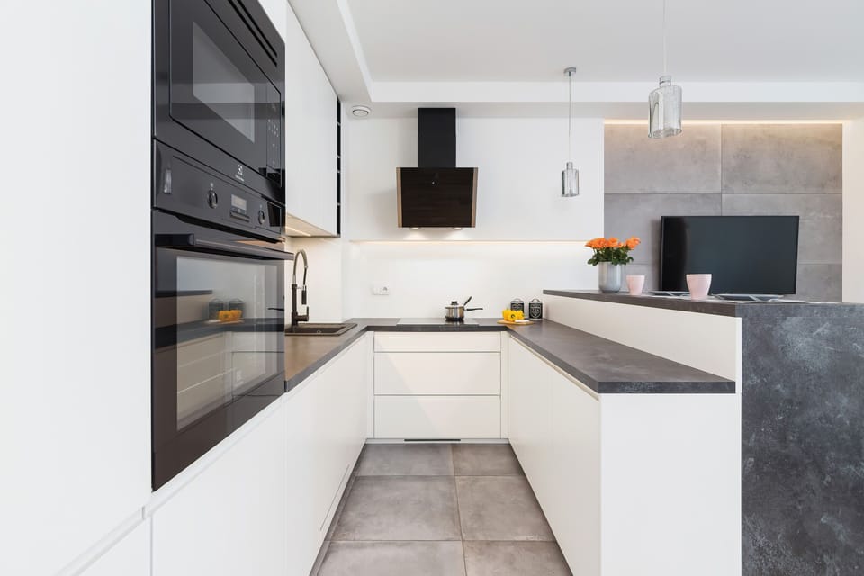 Modern annexe with white cabinets and appliances such as oven, microwave and dishwasher. The whole space is ideal for home-cooked meals.